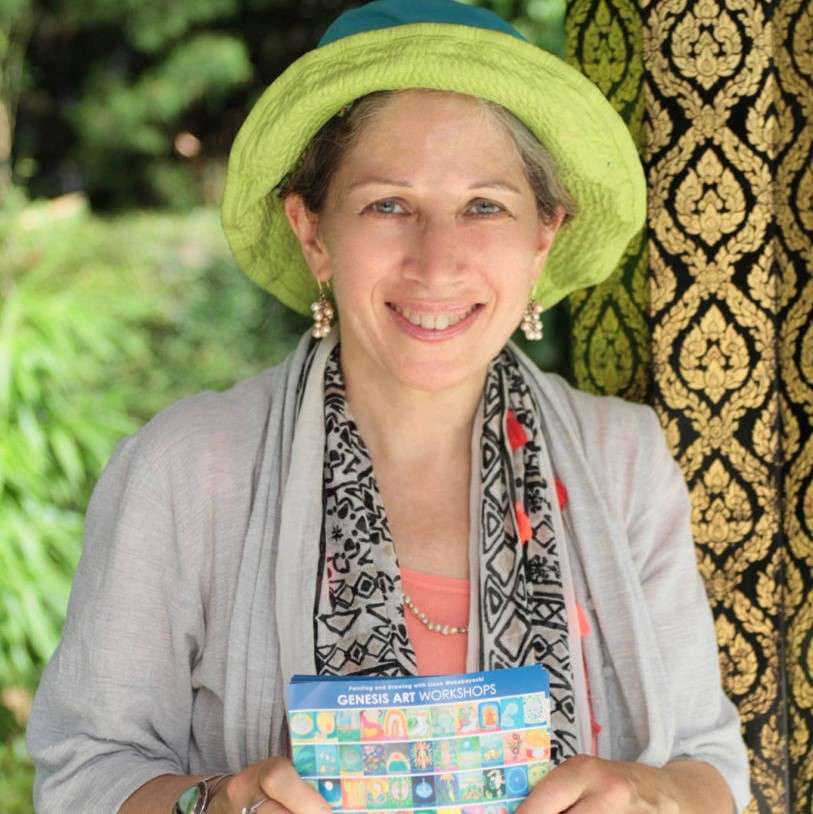 woman wearing green hat and gray top holding a colorful card